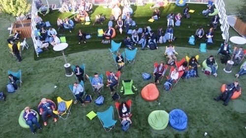 Attendees relax on a fake grass lawn laid out on a San Francisco street near the Moscone Center.
