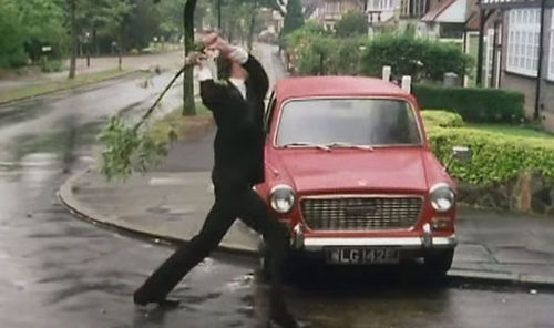 Basil Fawlty, played by John Cleese, gives his broken-down car a damn good thrashing.