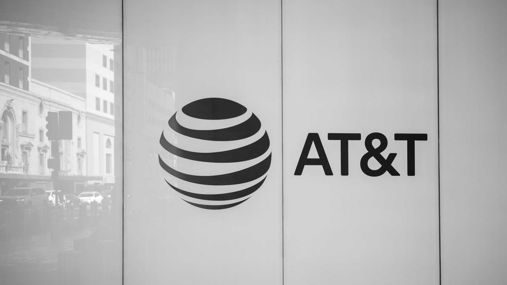 The AT&T logo at the company's Dallas headquarters building. The reflection shows the traffic piling up on Commerce Street. (Source: Phil Harvey/Light Reading)