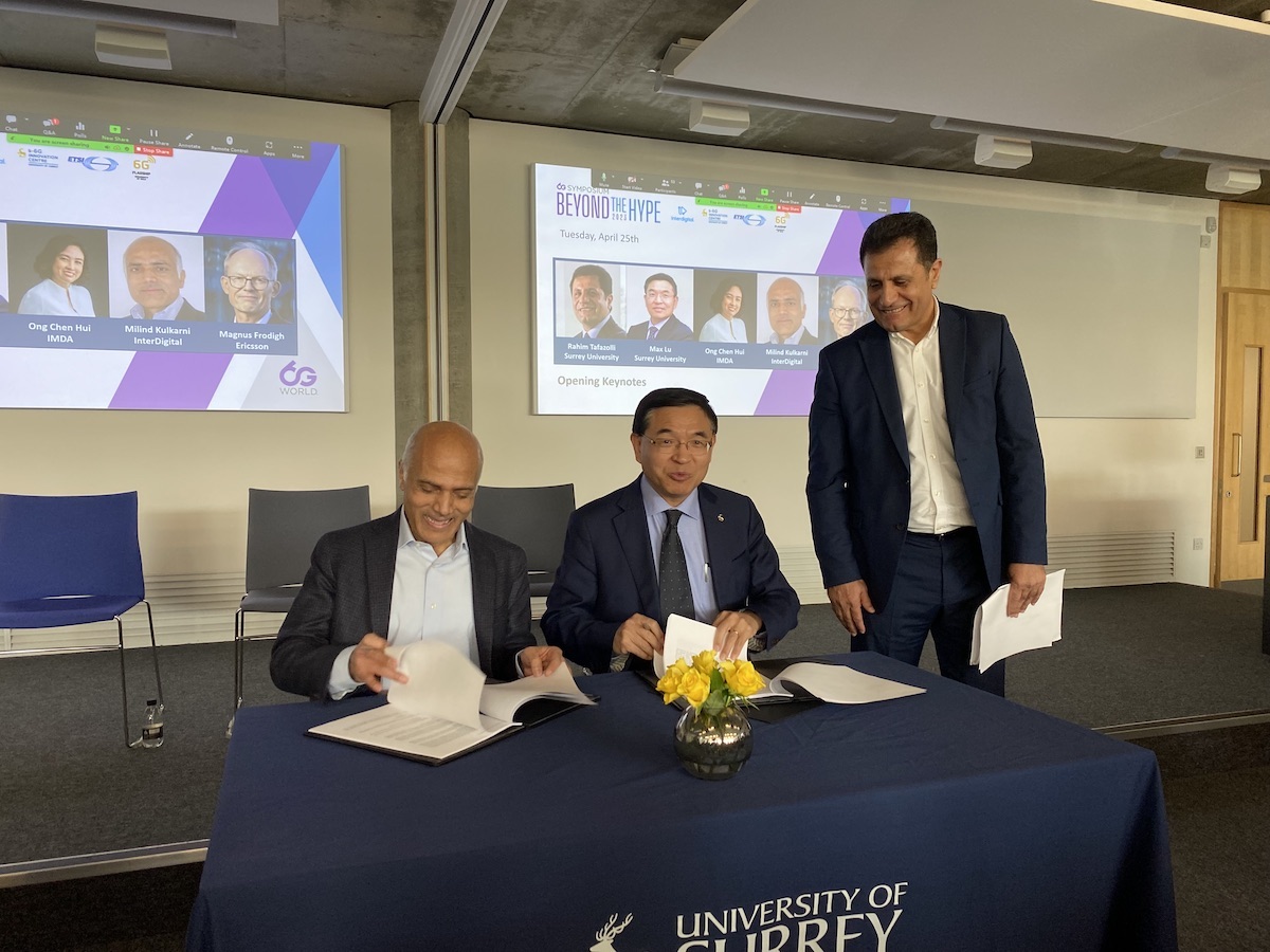 Interdigital's Milind Kulkarni (left) signs a 6G collaboration agreement with representatives of the University of Surrey. (Source: Iain Morris/Light Reading)