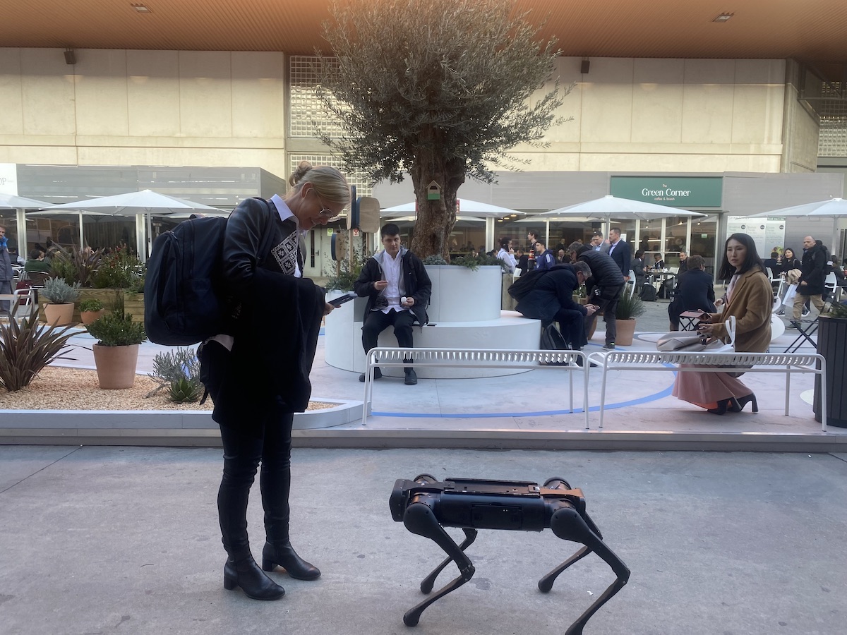 A visitor to Mobile World Congress says hello to a robot dog. (Source: Light Reading)