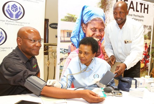 Joseph Ogutu, Chairman of the Safaricom Foundation, has his blood pressure checked by Eva Muchemi, Executive Director at the Kenya Diabetes Management and Information Center, during the Safaricom Mt. Kenya region dissemination forum at the White Rhino Hotel. Looking on is Joseph Mwangi, Health Coordinator, DMI.