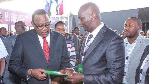 Kenyan President Uhuru Kenyatta speaks to Sitoyo Lopokoiyit, chief financial services officer at Safaricom, at the inaugural Afro-Asia Fintech Festival held at the Kenya School of Monetary Studies on July 15 and 16, 2019. 