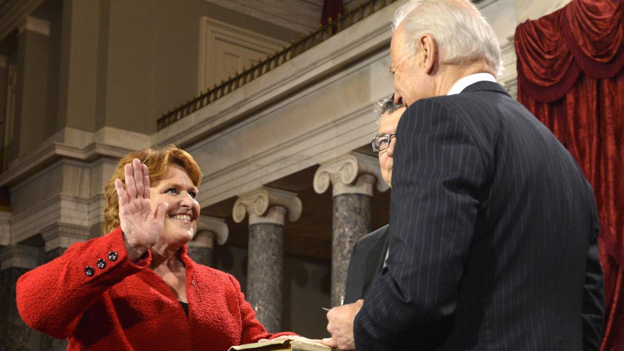 Former Democratic Senator Hedi Heitkamp is leading the latest campaign to derail President Joe Biden's nominee for FCC Commissioner, Gigi Sohn. Pictured is Heitkamp being sworn into the Senate in 2013 by then-VP Biden. (Source: UPI/Alamy Stock Photo)